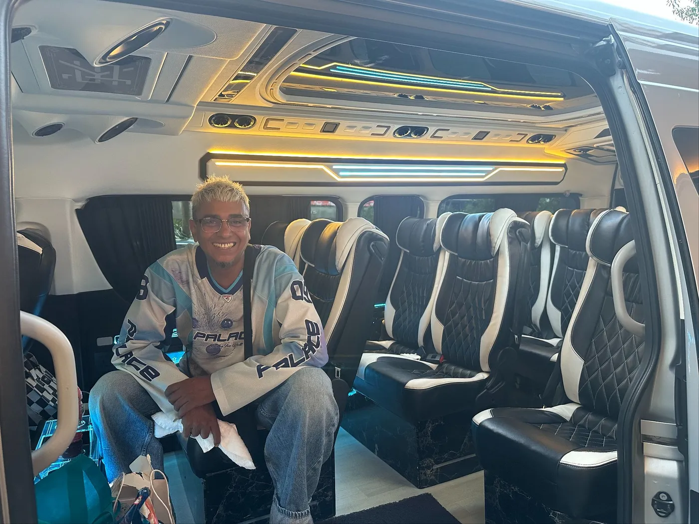Inside the VIP van, reclining captain seats under a lit ceiling